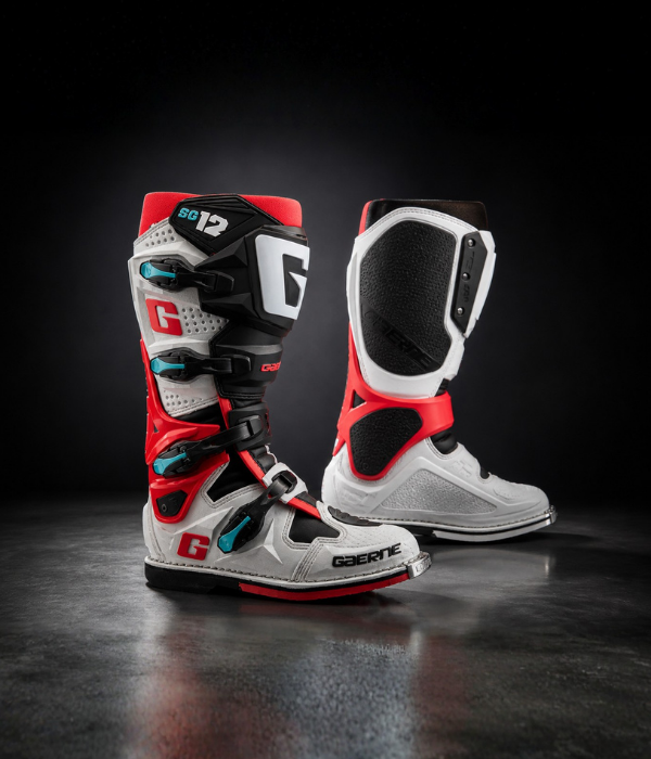 Gaerne SG12 motocross boots in red, white, and black with teal accents in a high-contrast studio environment collection