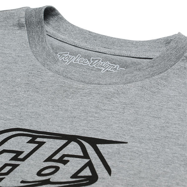 Crisp studio image on a white background of Troy Lee Designs Badge Tee; showing tee fit, printed graphics, and crew neckline; SKU 701568102; Sizes: S-2XL