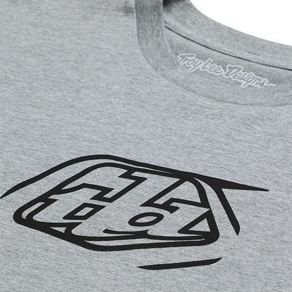 Professional studio photo of Troy Lee Designs Badge Tee; showing tee fit, printed graphics, and crew neckline; SKU 701568102; Sizes: S-2XL