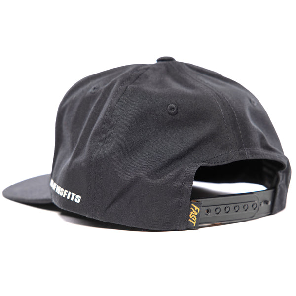 Fasthouse Spanner Hat SKU 3210050, back view showing adjustable black snapback closure with small yellow Fasthouse woven tag, durable motocross snapback cap.