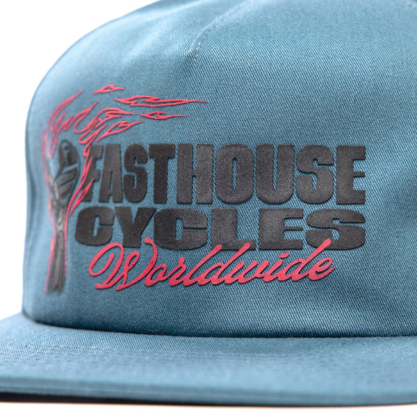 Close-up of Fasthouse Spanner Hat SKU 3210050 – detailed view of front panel showing motocross flame graphic and embroidered “Fasthouse Cycles Worldwide” lettering.