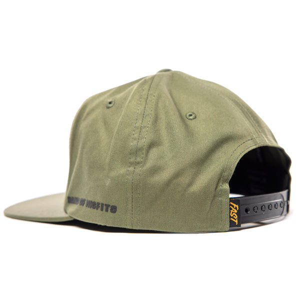 SKU 3210050 – Rear angle of Fasthouse Spanner Hat in olive green, showing adjustable snapback closure with black strap and woven yellow “Fast” tab, built for motocross and casual wear.
