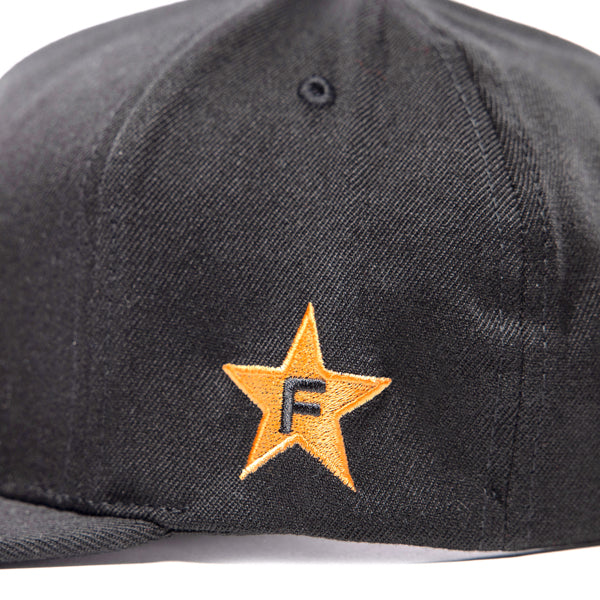 Close-up of the right side of the black Fasthouse Crown hat (SKU: 3210150), showing an embroidered gold star with a black