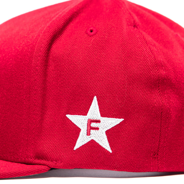A side view of the red Fasthouse Crown Hat (SKU 3210150), focusing on the right side. A large, white embroidered star is featured, with a red embroidered