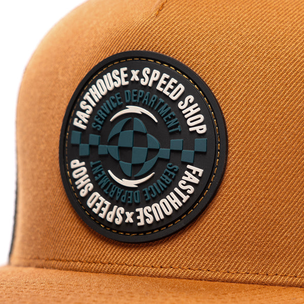 Close-up of Fasthouse Finch Hat SKU 3210070 showing detailed round Speed Shop Service Department patch with checkered racing design, durable stitching, motocross-inspired snapback style.