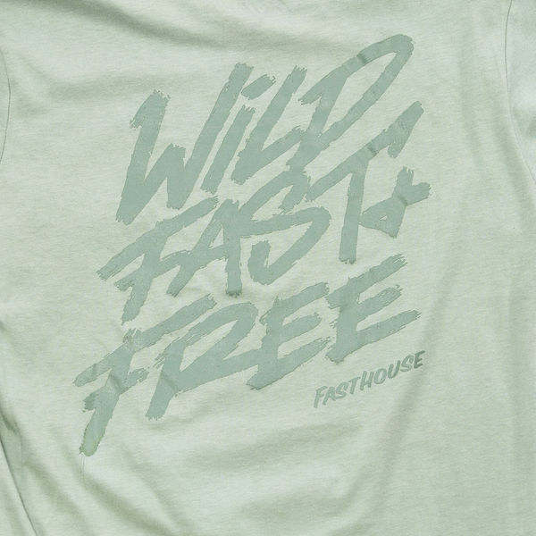 Back view of Fasthouse Wild Fast and Free women’s motocross lifestyle tee in worn sage, SKU 32111604. Large graphic text reads “Wild Fast Free” with Fasthouse branding in bold brush lettering.