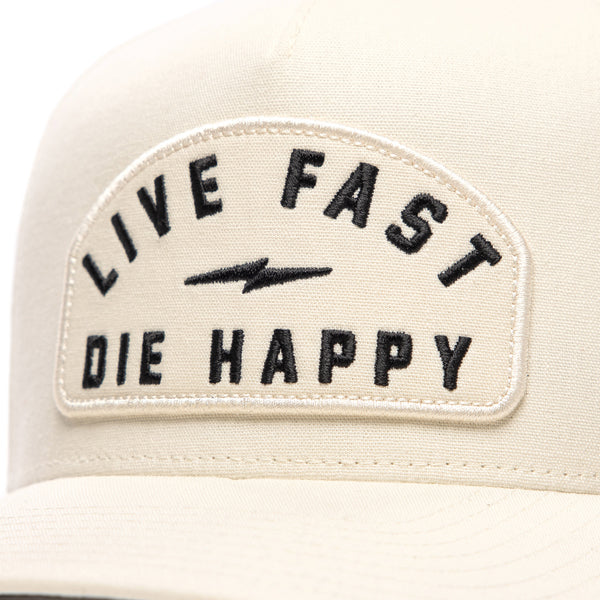 Close-up front view of Fasthouse Wired Hat SKU 3321098 in chalk white, showing bold black embroidery “Live Fast Die Happy” with lightning bolt design on structured crown, motocross casual headwear.