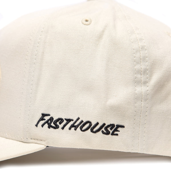 Side view of Fasthouse Wired Hat SKU 3321098 in chalk white, featuring black embroidered Fasthouse logo on the panel above the brim, durable snapback motocross cap.
