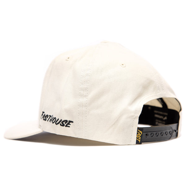 Rear angled view of Fasthouse Wired Hat SKU 3321098 in chalk white, showing adjustable black snapback strap with yellow Fasthouse branding tag and side logo embroidery, motocross casual wear.