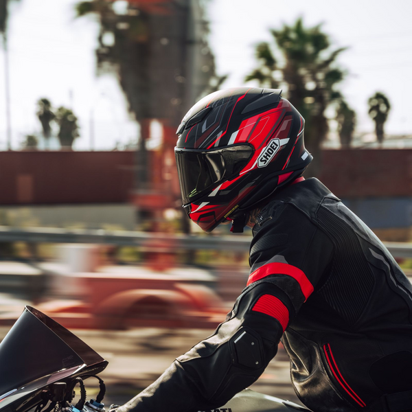 man wearing red and black shoei helmet and riding a motorcycle collection