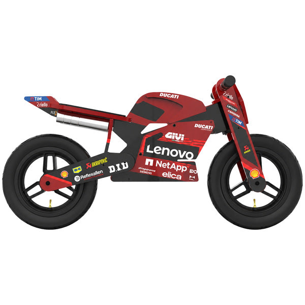 Kiddimoto Ducati Desmo GP25 wooden balance bike shown from the side, featuring a red MotoGP-inspired body, black wheels, black pneumatic tires, black seat and handlebars, white accents, and Ducati racing sponsor logos. SKU 6391000150, UPC 5060840317954.