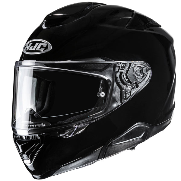 805028803 | A black full-face motorcycle helmet with a clear visor, featuring a silver HJC logo on the front top, sleek aerodynamic design with smooth curves, and detailed mechanical components visible on the side near the hinge, set against a plain white background with even lighting that highlights the helmet's glossy finish and contours. | Available at BTO Sports