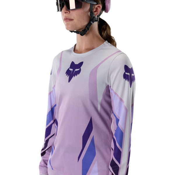 Fox Racing Ranger Foundry Long Sleeve Jersey (MTB) (Womens) in Lavender Drift, modeled front three-quarter view, with the crew neck, long sleeves, contrasting shoulder and arm graphics, and extended rear hem on a rider. Available options—Color: Lavender Drift; Size: XS, SM, MD, LG, XL. SKU 40170-F07-M. UPC 198571115466.