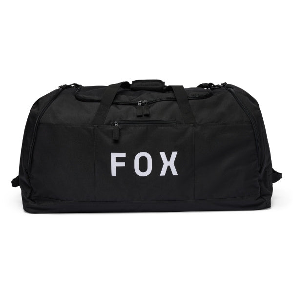 Fox Racing Podium Duffle in Black, long-side view, with the main zippered compartment, reinforced base, carry handles, end pocket, wheels, and large Fox logo. Available options—Color: Black, Red, Blue Jewel. SKU 39031-001-OS. UPC 198571122495.