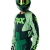 Fox Racing 180 Raid Jersey in Deep Fern, modeled front three-quarter view, with the crew neck, long sleeves, contrasting shoulder and arm graphics, and extended rear hem on a rider. Available options—Color: Rust, Purple Lava, Deep Fern; Size: XS, SM, MD, LG, XL, 2X. SKU 40655-D10-M. UPC 198571125021.