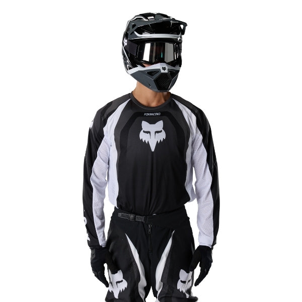 Fox Racing 180 Frame Jersey in Black, close-up of the sleeve graphic and cuff, with the printed Fox artwork, mesh-knit texture, reinforced seam lines, and shaped cuff or hem. Available options—Color: Blue, Grey/Yellow, Black, Red; Size: XS, SM, MD, LG, XL, 2X, 3X. SKU 40665-001-XL. UPC 198571122235.