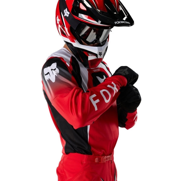 Fox Racing 180 Frame Jersey in Red, modeled front three-quarter view, with the crew neck, long sleeves, contrasting shoulder and arm graphics, and extended rear hem on a rider. Available options—Color: Blue, Grey/Yellow, Black, Red; Size: XS, SM, MD, LG, XL, 2X, 3X. SKU 40665-003-M. UPC 198571129852.