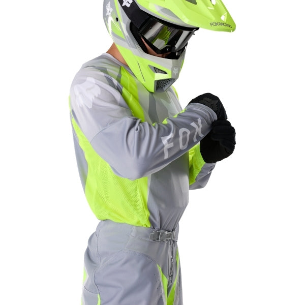 Fox Racing 180 Frame Jersey in Grey/Yellow, close-up of the chest and shoulder panels, with the printed Fox artwork, mesh-knit texture, reinforced seam lines, and shaped cuff or hem. Available options—Color: Blue, Grey/Yellow, Black, Red; Size: XS, SM, MD, LG, XL, 2X, 3X. SKU 40665-086-L. UPC 198571126080.