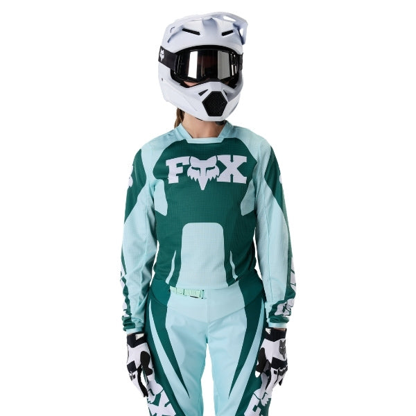 Fox Racing 180 Raid Jersey (Womens) in Melon, close-up of the lower hem and drop-tail panel, with the printed Fox artwork, mesh-knit texture, reinforced seam lines, and shaped cuff or hem. Available options—Color: Lavender Drift, Melon; Size: XS, SM, MD, LG, XL.
