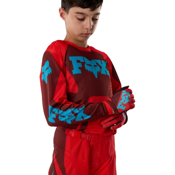 Fox Racing 180 Raid Jersey (Youth) in Rust, close-up of the chest and shoulder panels, with the printed Fox artwork, mesh-knit texture, reinforced seam lines, and shaped cuff or hem. Available options—Color: Rust, Purple Lava; Size: Y-SM, Y-MD, Y-LG, Y-XL. SKU 40673-180-YXL. UPC 198571130988.