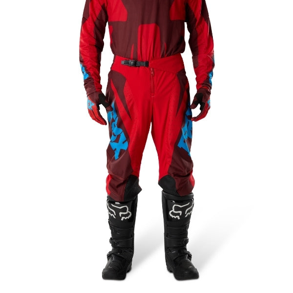Fox Racing 180 Raid Pants in Rust, close-up of the side thigh and knee panels, with the ratcheting waist adjuster, stretch yoke, shaped hip panel, and reinforced knee or thigh material. Available options—Color: Rust, Purple Lava, Deep Fern; Size: 28, 30, 32, 34, 36, 38. SKU 40685-180-36. UPC 198571130933.