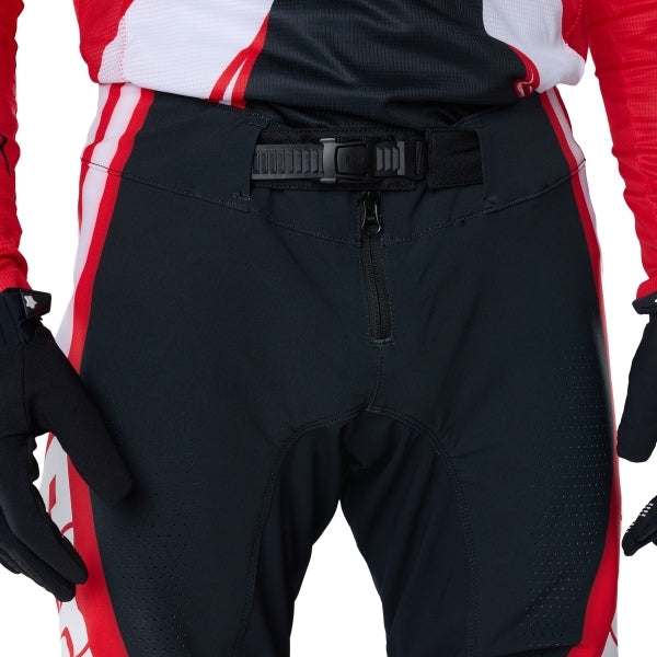 Fox Racing Flexair Thorn Pants in Red, close-up of the waist and hip panels, with the ratcheting waist adjuster, stretch yoke, shaped hip panel, and reinforced knee or thigh material. Available options—Color: Black/White, Purple Lava, Red; Size: 28, 30, 32, 34, 36, 38. SKU 40688-003-32. UPC 198571130247.