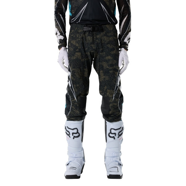 Fox Racing Flexair Apex Pants in Black, close-up of the side thigh and knee panels, with the ratcheting waist adjuster, stretch yoke, shaped hip panel, and reinforced knee or thigh material. Available options—Color: Black; Size: 28, 30, 32, 34, 36, 38. SKU 40690-001-36. UPC 198571133613.