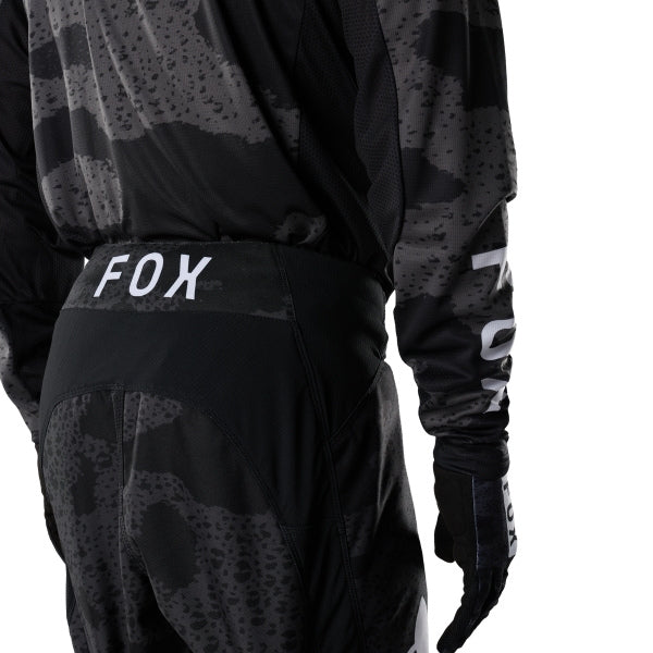 Fox Racing 180 BNKR Pants in Black Camo, close-up of the ratcheting waist closure, with the ratcheting waist adjuster, stretch yoke, shaped hip panel, and reinforced knee or thigh material. Available options—Color: Black Camo; Size: 26, 28, 30, 32, 34, 36, 38. SKU 40694-247-32. UPC 198571133675.