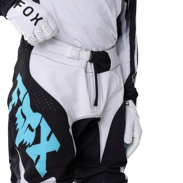 Fox Racing 360 Clutch Pants in White/Black, close-up of the waist and hip panels, with the ratcheting waist adjuster, stretch yoke, shaped hip panel, and reinforced knee or thigh material. Available options—Color: White/Black, Neon Pink; Size: 28, 30, 32, 34, 36, 38. SKU 40707-058-32. UPC 198571132562.