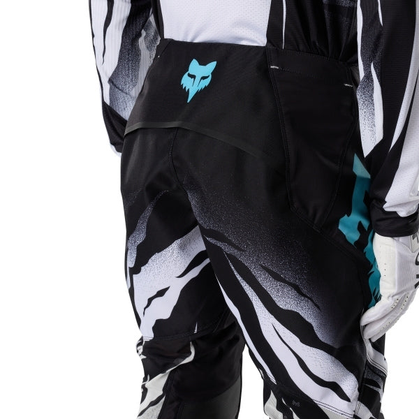 Fox Racing 360 Clutch Pants in White/Black, close-up of the ratcheting waist closure, with the ratcheting waist adjuster, stretch yoke, shaped hip panel, and reinforced knee or thigh material. Available options—Color: White/Black, Neon Pink; Size: 28, 30, 32, 34, 36, 38. SKU 40707-058-34. UPC 198571132579.