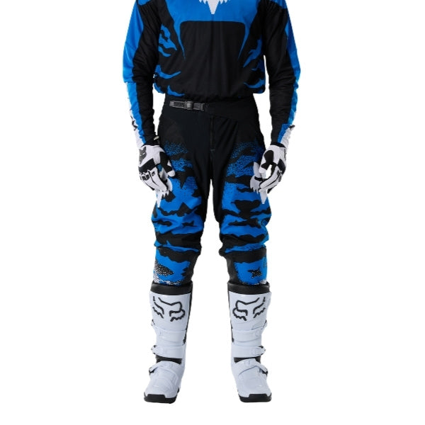 Fox Racing 180 HD38 Pants in Black/Blue, close-up of the side thigh and knee panels, with the ratcheting waist adjuster, stretch yoke, shaped hip panel, and reinforced knee or thigh material. Available options—Color: Black/Blue; Size: 26, 28, 30, 32, 34, 36, 38. SKU 40709-013-34. UPC 198571135266.