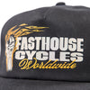 Fasthouse Spanner Hat SKU 3210050 in black, angled front view with flat brim, displaying Fasthouse Cycles Worldwide logo and flame piston artwork, motocross streetwear snapback.