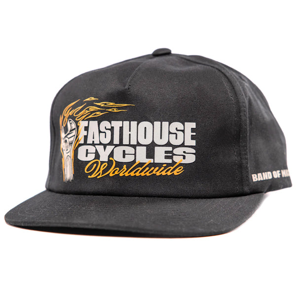 Fasthouse Spanner Hat SKU 3210050 in black, front view showing bold Fasthouse Cycles Worldwide logo in white and gold with flaming piston graphic, motocross lifestyle snapback hat.